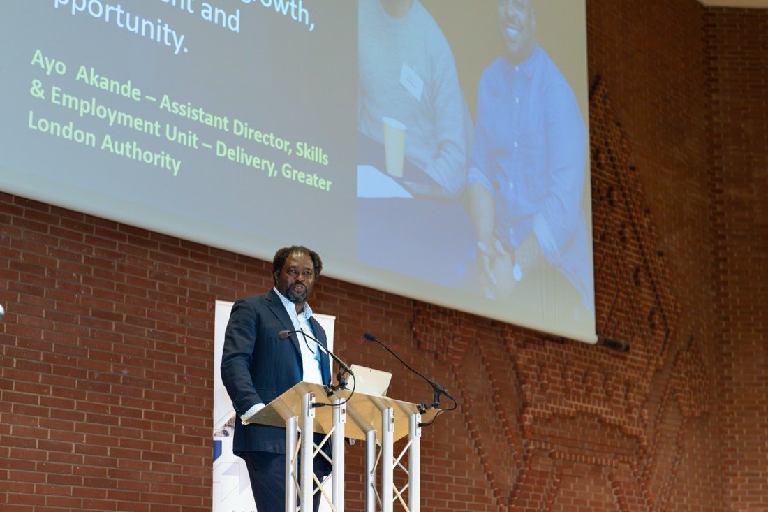 Ayo Akande on stage at an employment event