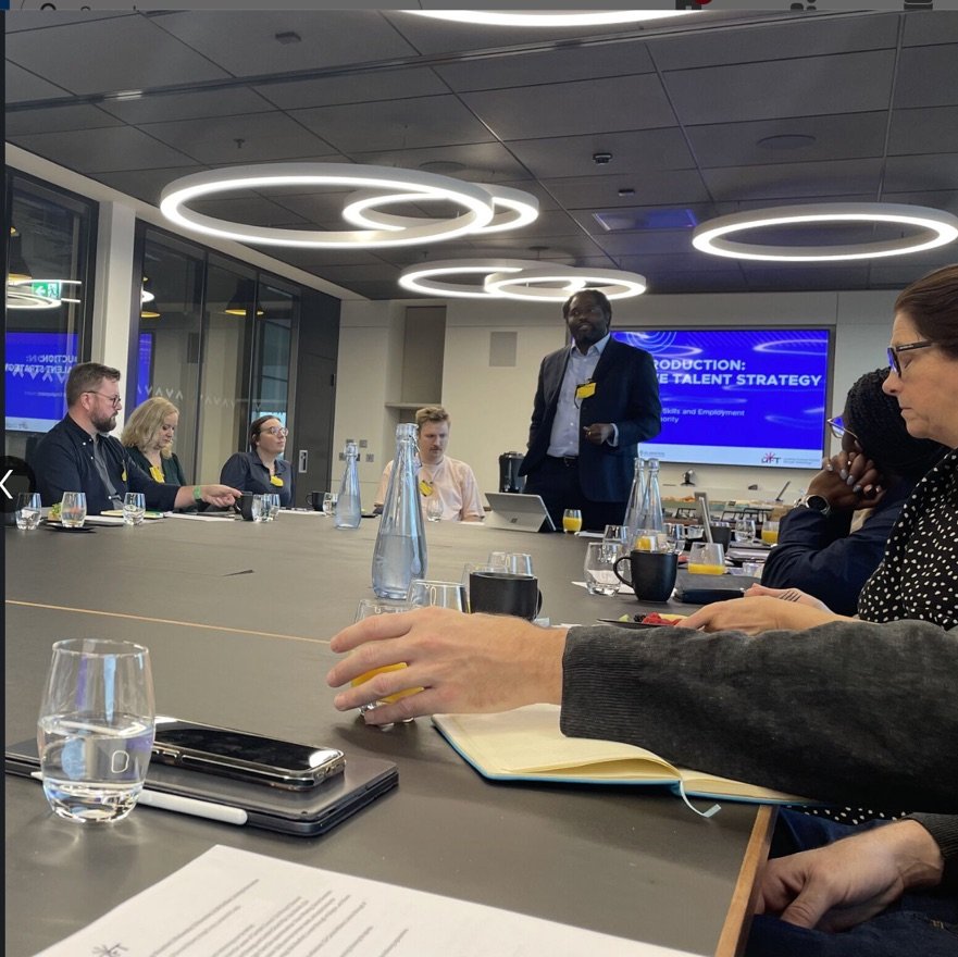 Ayo Akande presenting at a round-table meeting